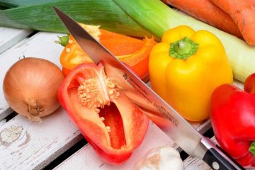 Ein Messer teil eine rote und gelbe Paprika voneinander. Ob das einer der Unterschiede zwischen HelloFresh und Marleyspoon ist?